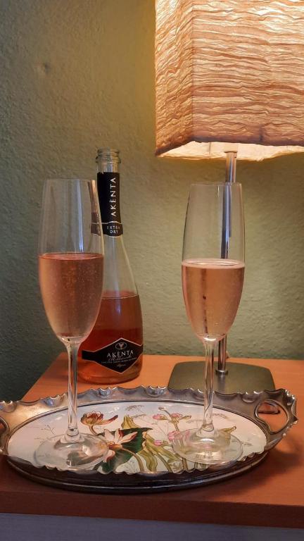 two glasses of wine on a table with a bottle of wine at Villa Kuky in Santa Teresa Gallura