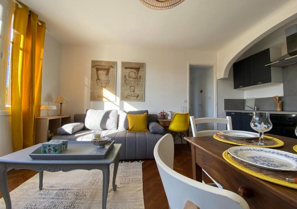 un soggiorno con divano e tavolo di Yellow'appart #Moulin#1 -Futuroscope-jardin & parking - La Conciergerie a Jaunay-Clan