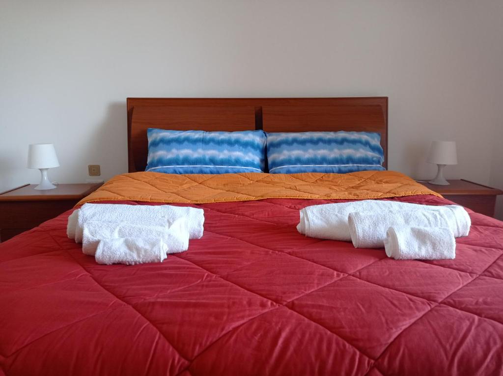 a large red bed with two white towels on it at Appartamento Vistamare 20 in Bari