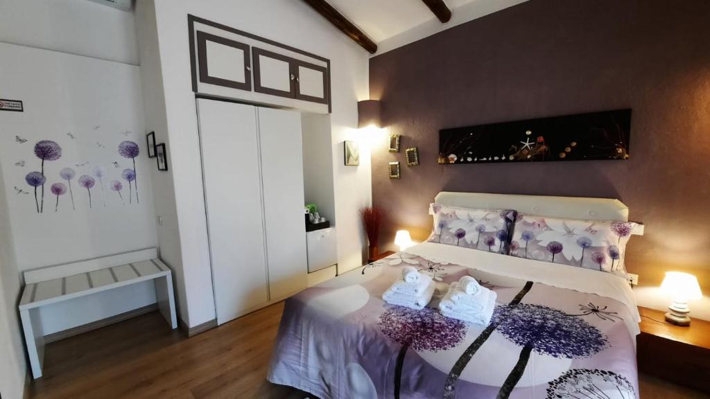 a bedroom with a large bed with purple accents at Villa Kuky in Santa Teresa Gallura