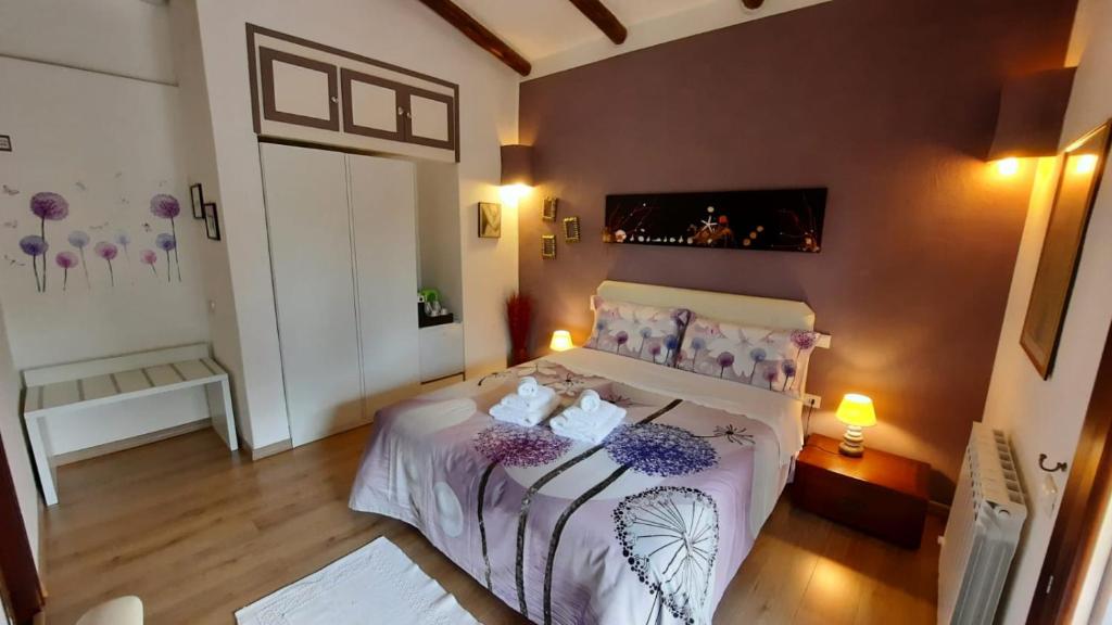 a bedroom with a bed with purple flowers on it at Villa Kuky in Santa Teresa Gallura