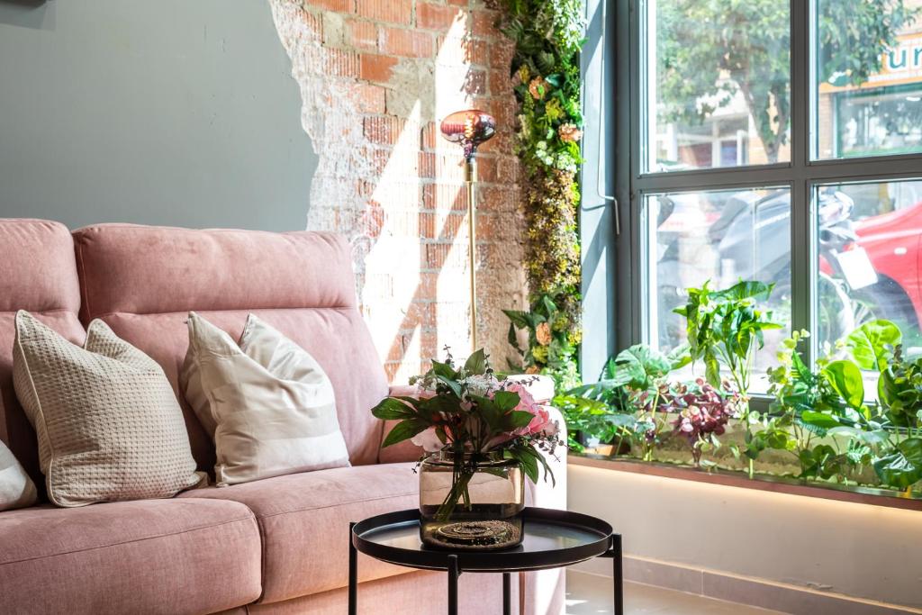 ein Wohnzimmer mit einem rosa Sofa und einem Tisch in der Unterkunft Encantador Loft a un Paso del Río Turia in Valencia