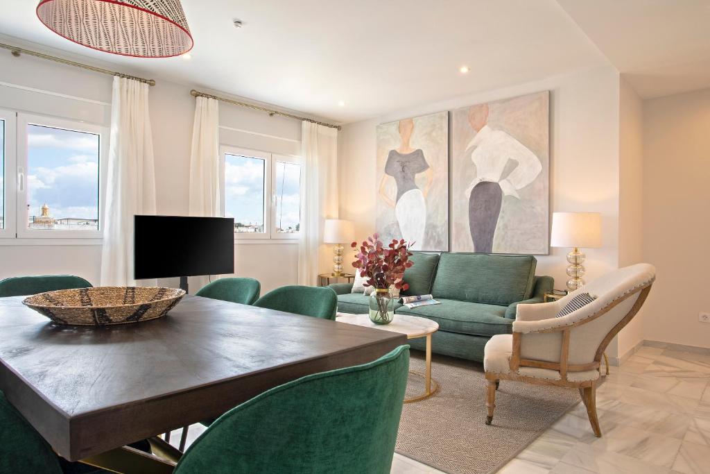 a living room with a table and green chairs at Genteel Home Constitución in Seville