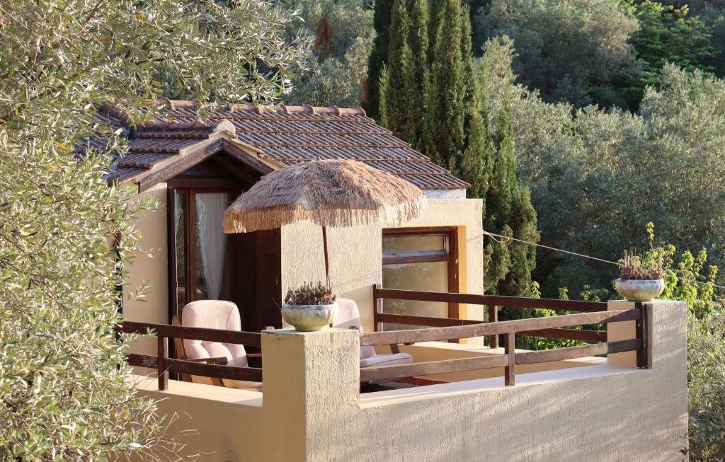 a small house with two chairs and a roof at Olive Yard House in Skopelos Town