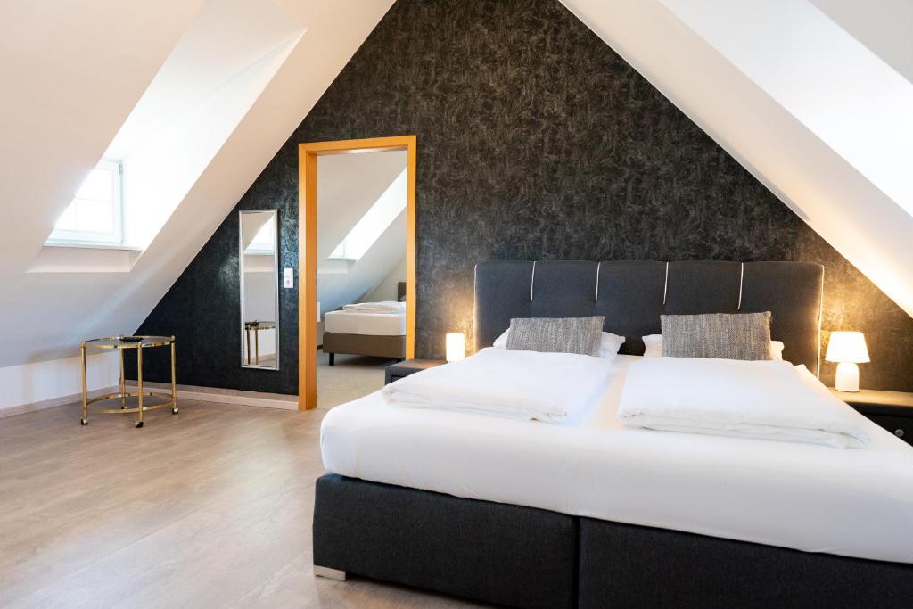 1 dormitorio con 1 cama grande y espejo grande en La Fleur Appartement en Überlingen