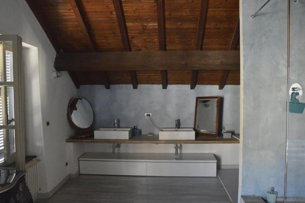 un bagno con due lavandini e uno specchio sul muro di B&B Giardinidivale a 2 chilometri da Finale Ligure a Borgio Verezzi