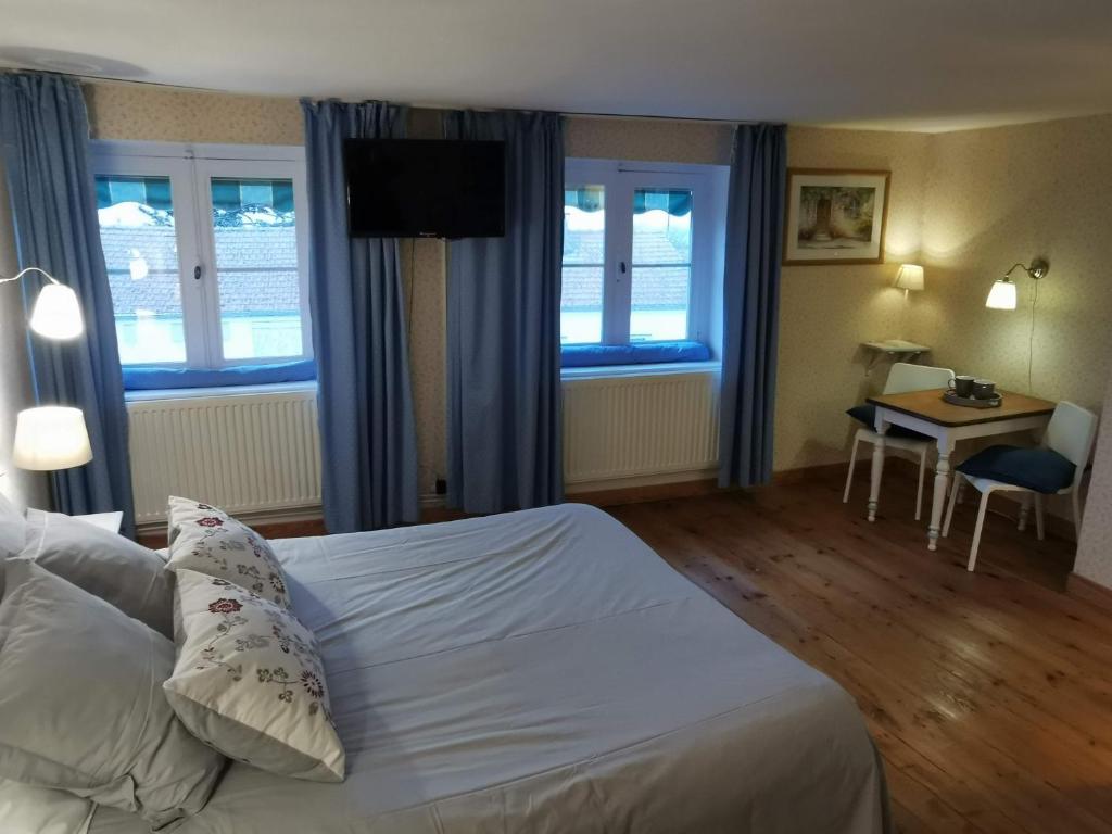 a hotel room with a bed and a table with a desk at La maison de Céline in Arry