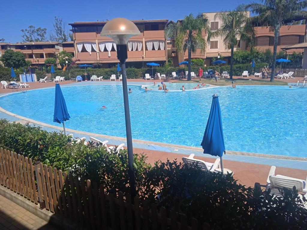 una piscina en un complejo con gente nadando en él en Casa EleGiò - Blue Village 2 en Marina di Pisticci