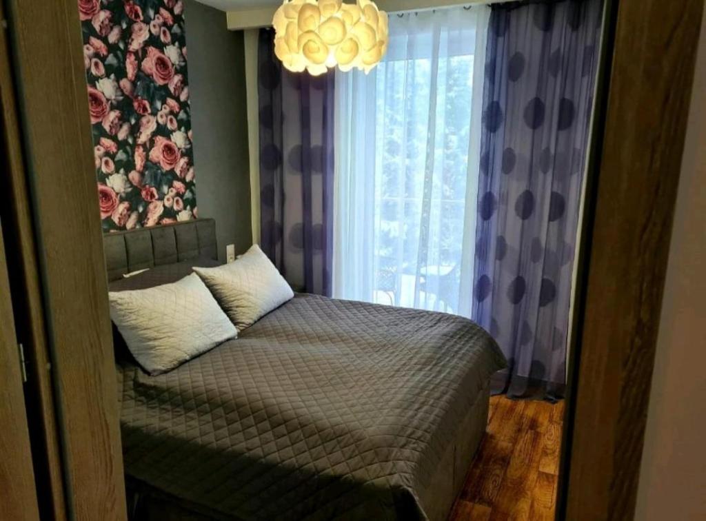 a bedroom with a bed with a large window at Apartament Rewal in Rewal