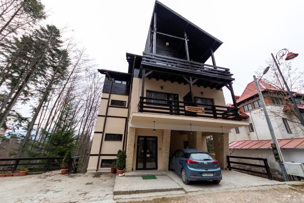 een huis met een auto ervoor geparkeerd bij Pension Master in Sinaia