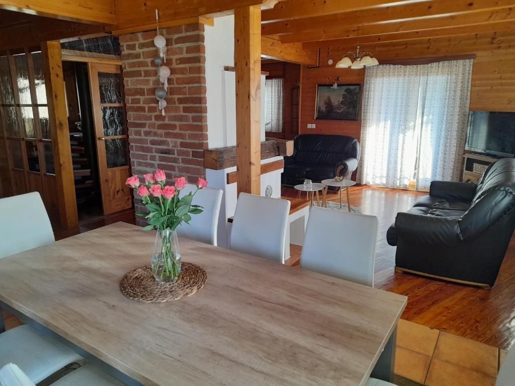 una mesa de comedor con un jarrón de flores. en Logarska koča, en Fokovci