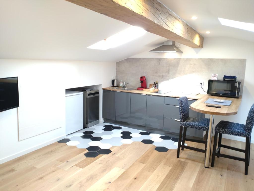 a kitchen with a table and two chairs and a counter at studio cocoon BORDEAUX Chartrons/ Jardin Public in Bordeaux