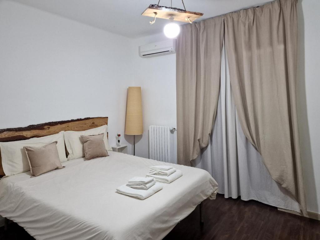 - une chambre avec un lit blanc et des serviettes dans l'établissement SAINT GEORGE'S HOUSE Bari, à Bari