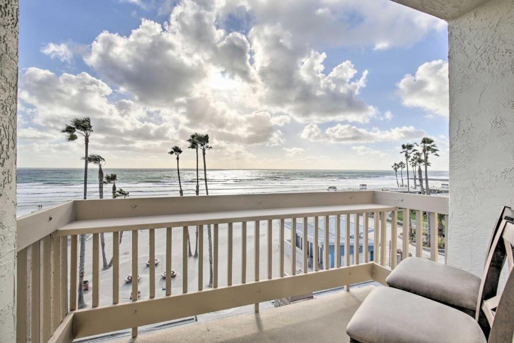 a balcony with a view of the beach and palm trees at Heavenly Oceanfront Condo with Amenities Galore in Oceanside