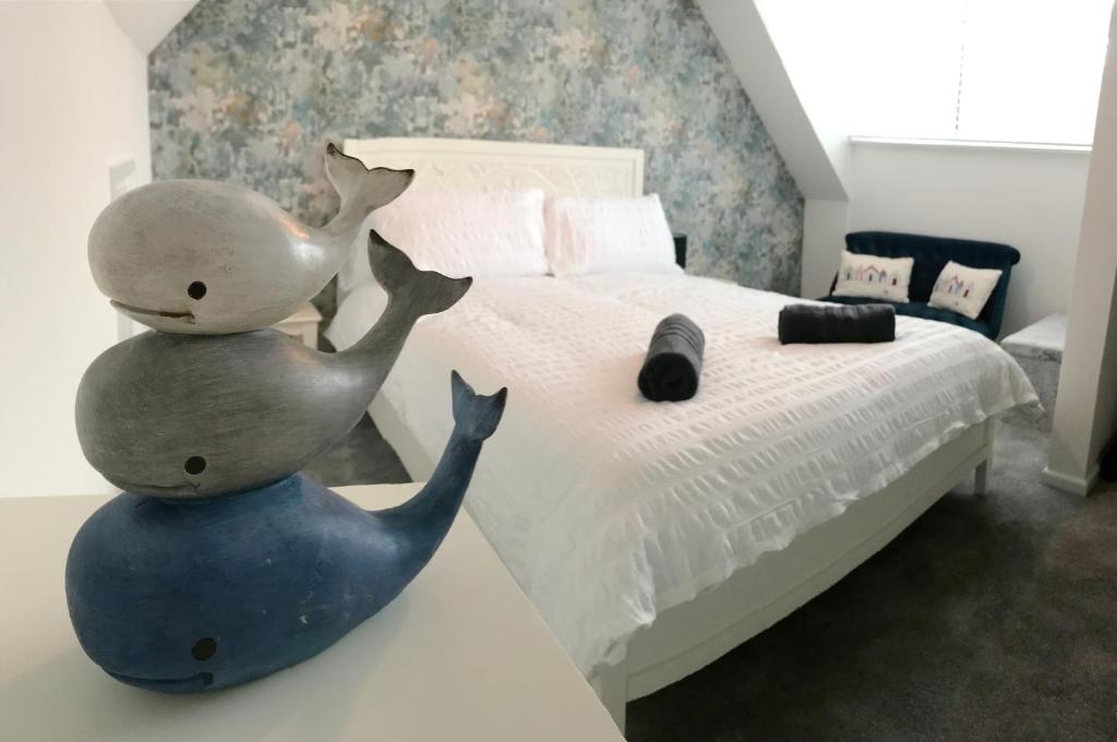 ボーンマスにあるThe Beach Hut - 1 Bedroom Apartment Near the Beachのベッドルーム1室(ベッド1台にクジラ2頭の像付)