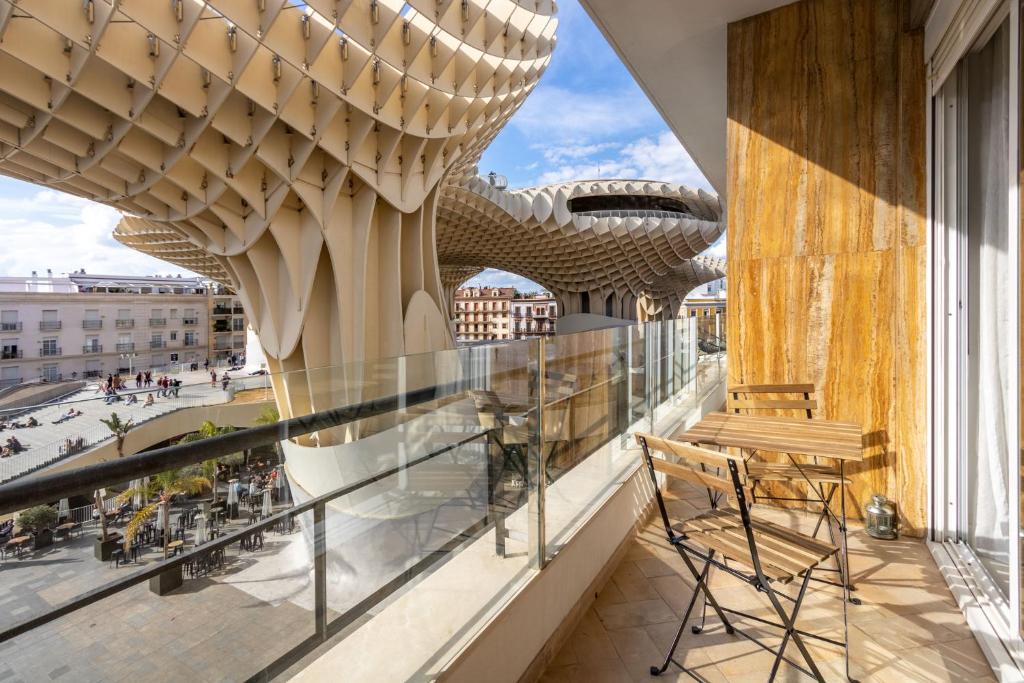 einen Balkon mit einer Bank und Stadtblick in der Unterkunft Imagen Metrosol Deluxe by Valcambre in Sevilla