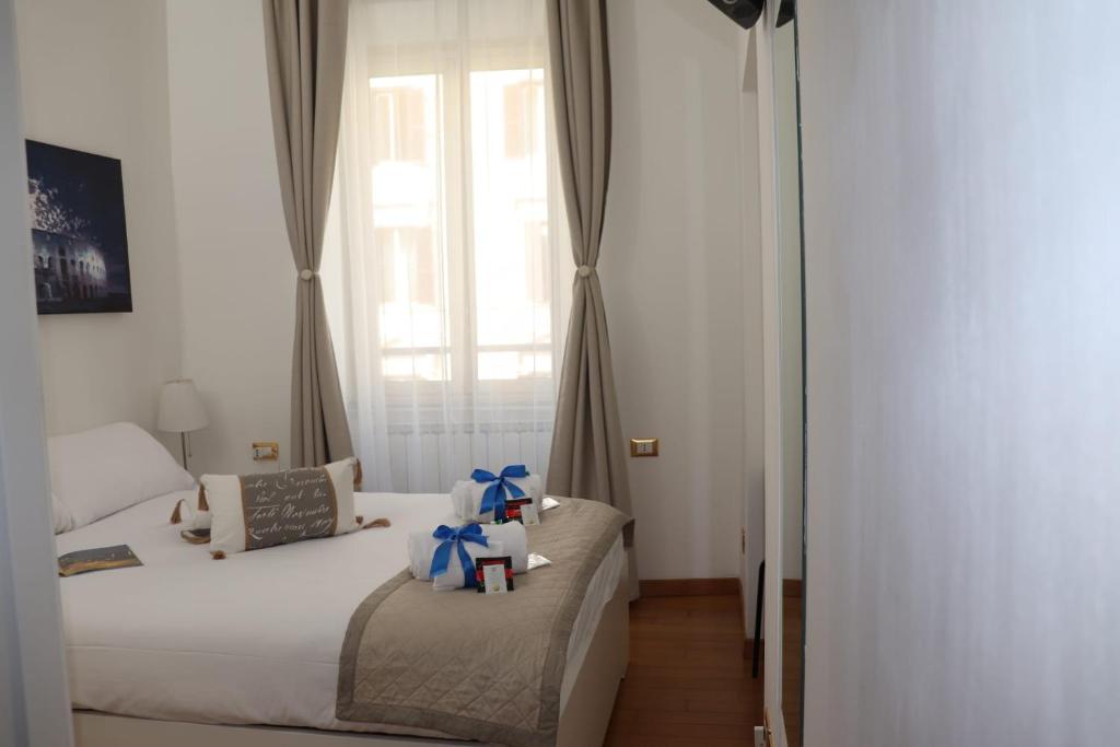 ローマにあるB&B Gaudium Colosseoのベッド2台と窓が備わるホテルルームです。