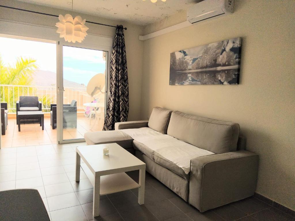 a living room with a couch and a table at OceanBlue Modern king size 1 Bedroom Apartment with Seaview and Terrace in Chayofa