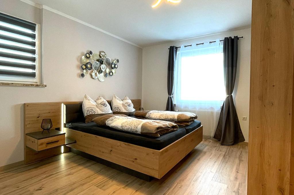 um quarto com uma cama e uma janela em Schöne Ferienwohnung, Familienfreundlich 130m2 em Greifenburg