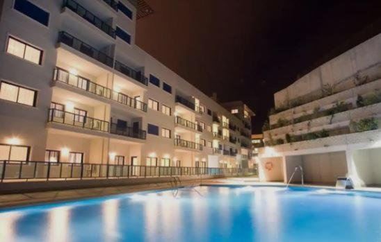 a large swimming pool in front of a building at Alicante Hills Luxury Beach Apartment in Alicante