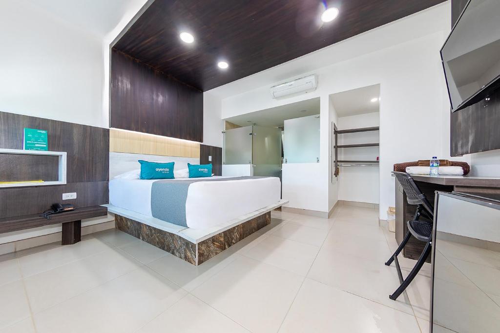 ein Schlafzimmer mit einem großen weißen Bett und einem Waschbecken in der Unterkunft Ayenda San Antonio Plaza in Apartadó