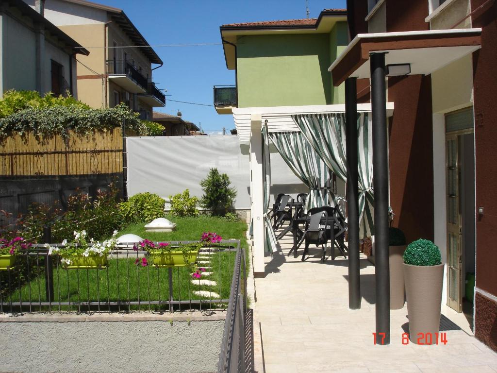 un patio trasero con un jardín con flores y una valla en Blau Vacanze en Peschiera del Garda