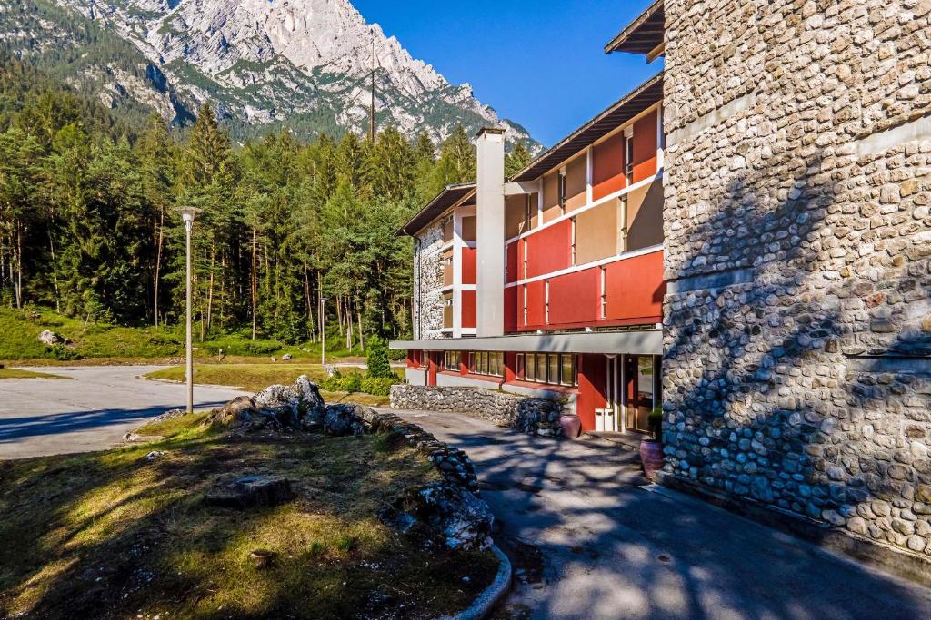 um edifício de resort com uma montanha ao fundo em Appartamenti Corte Residence em Borca di Cadore