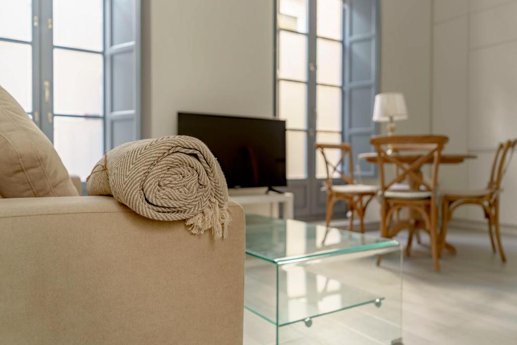 Hotel APARTAMENTO GARDEN ART III, a living room with a couch and a glass table at APARTAMENTO GARDEN ART III in Granada