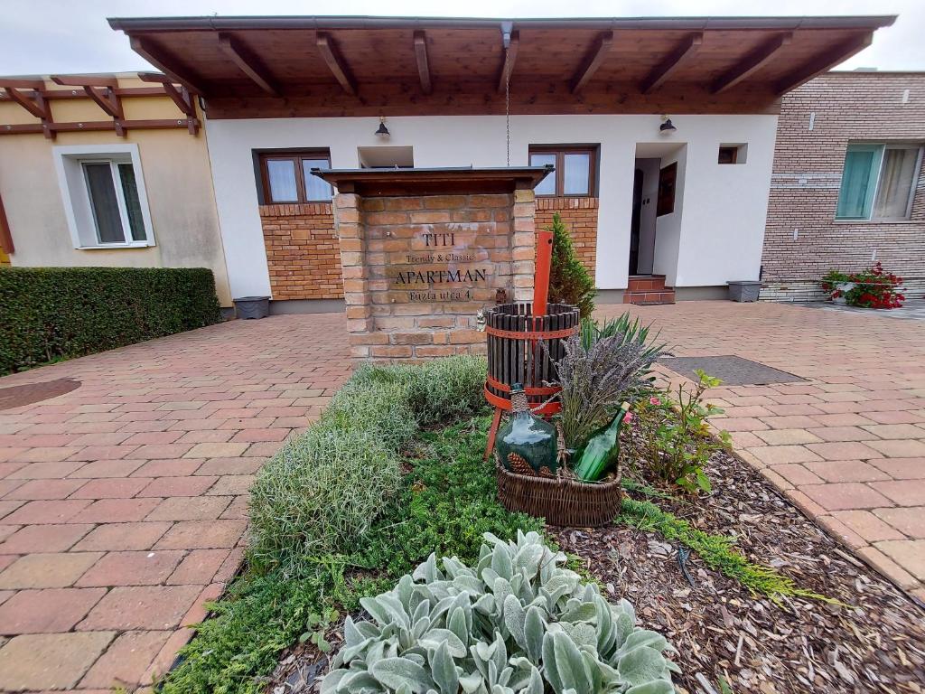 un jardín con plantas frente a un edificio en Titi Classic & Trendy Apartman, en Bük