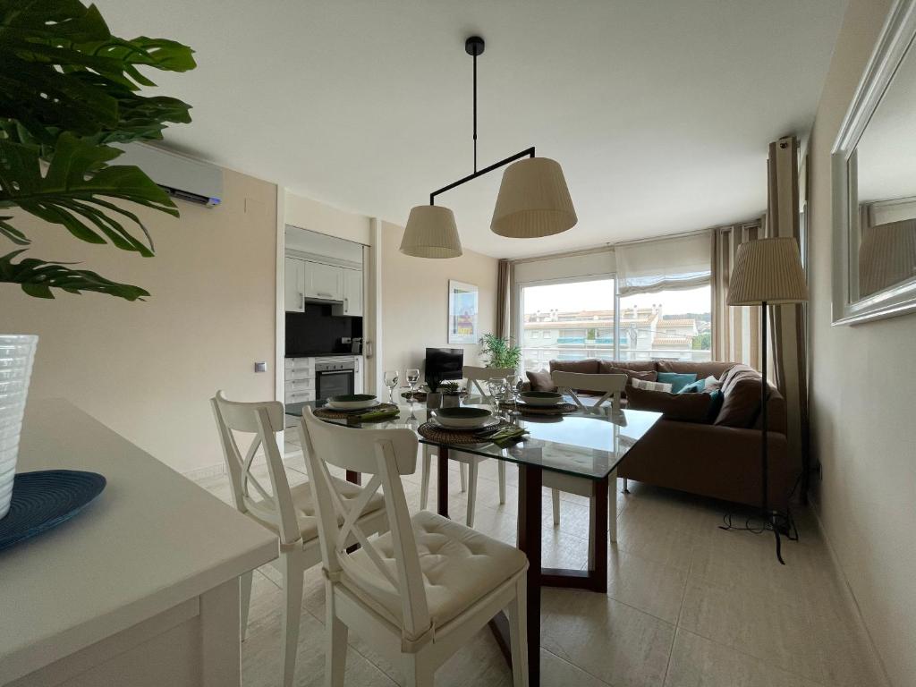 a kitchen and living room with a table and chairs at A 600 metros de la playa, ideal para familias in S'agaro