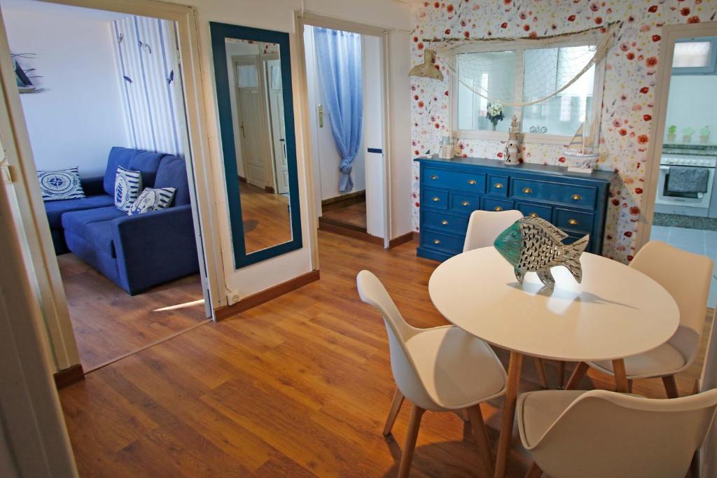 um quarto com uma mesa e cadeiras e um armário azul em LA MAR SALADA em Lastres