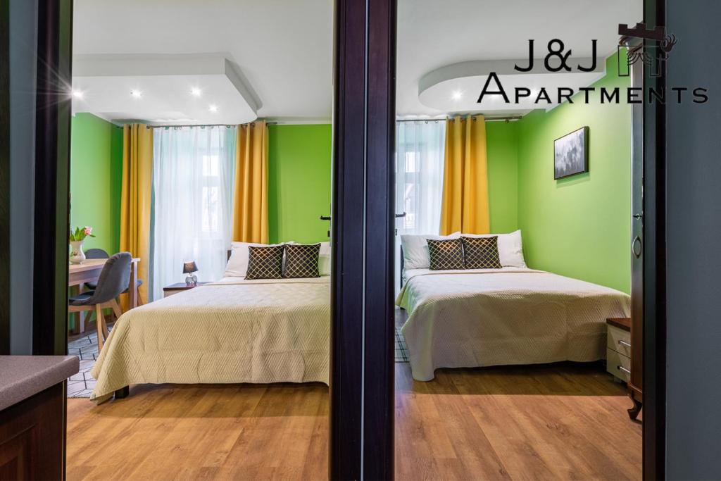 2 camas en una habitación con paredes de color verde y naranja en J&J Apartments, Szczytna 1, Apartament 9, en Toruń