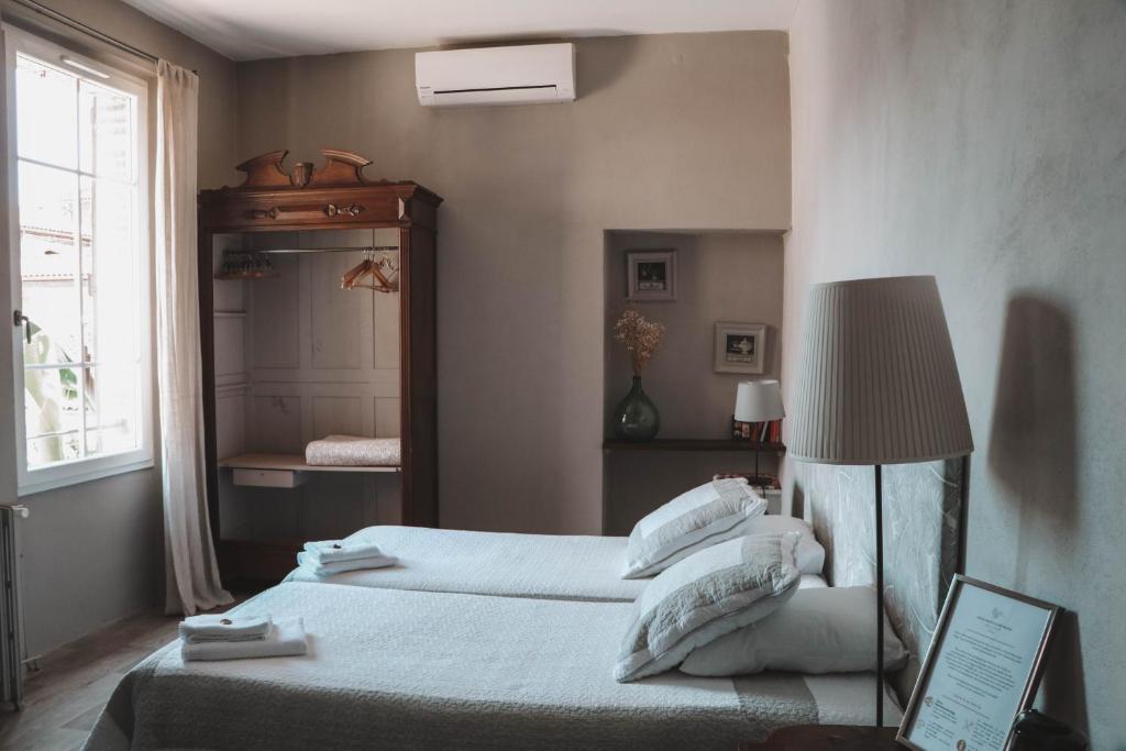 een slaapkamer met 2 bedden, een lamp en een spiegel bij Maison d'Hotes Delga in Gaillac
