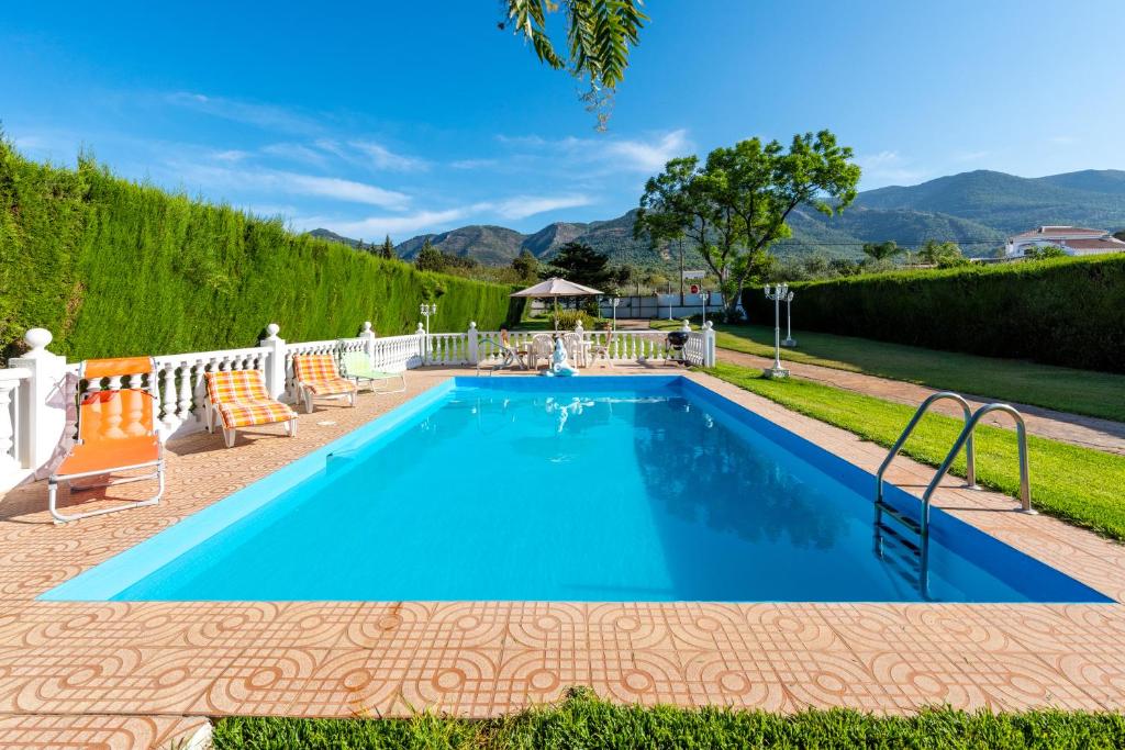a swimming pool in a yard with a gazebo at La Casa del Campo de Mis Rapaciños in Alhaurín el Grande