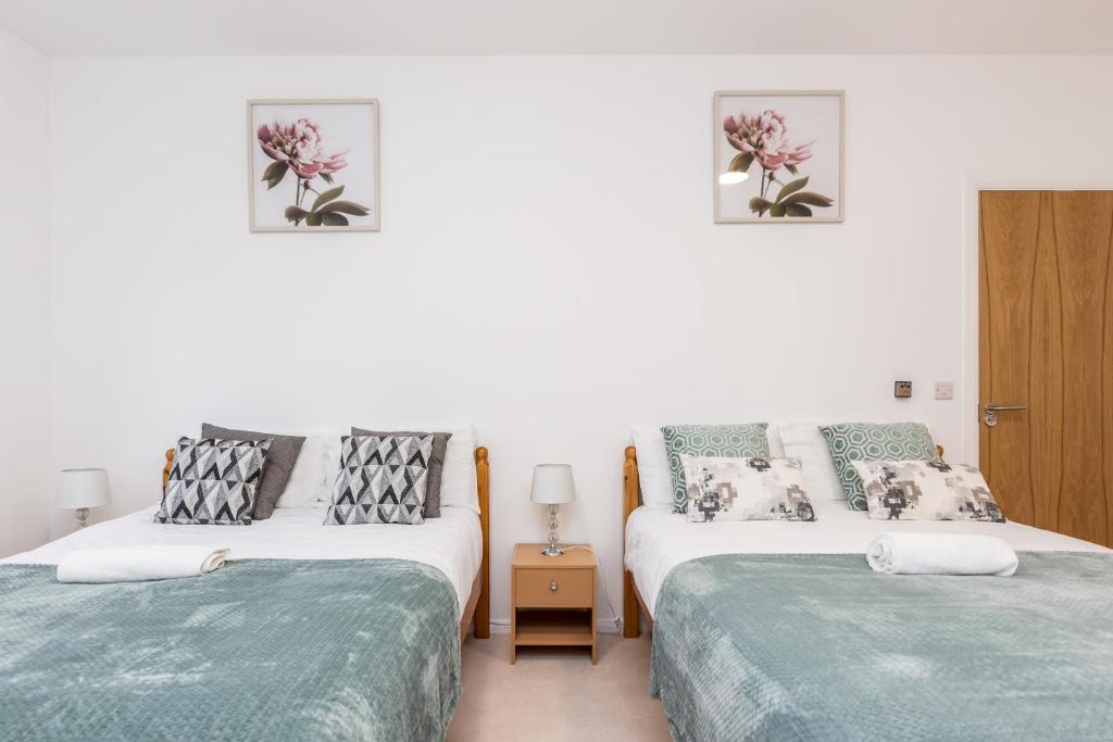 ダートフォードにある2BR Apt-Sleeps 5-Accessible-Central Dartfordの白い壁の部屋にベッドが2つある