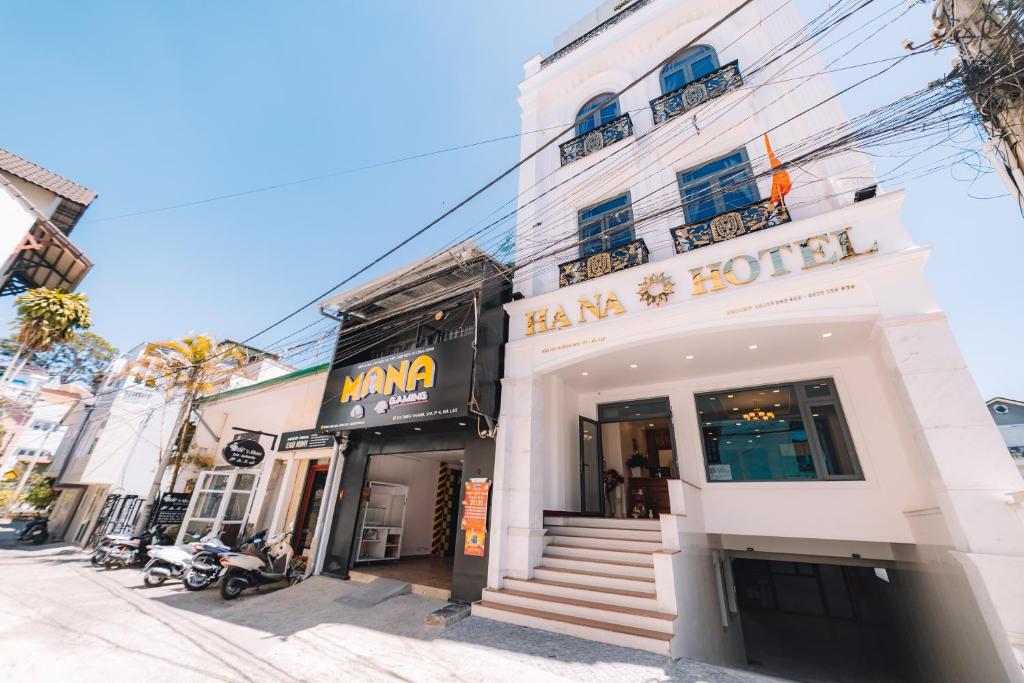 un bâtiment blanc avec un magasin dans une rue dans l'établissement Hạ Na Hotel Đà Lạt, à Đà Lạt