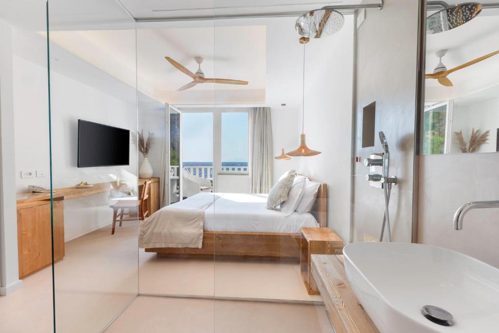 a bedroom with a bed and a bathroom with a tub at Maya Beach Resort in Massa Lubrense