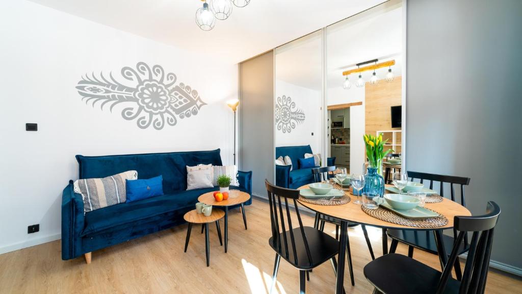 HELLO Apartamenty - Pozytywka z widokiem na Śnieżkę في كارباش: غرفة معيشة مع أريكة زرقاء وطاولة
