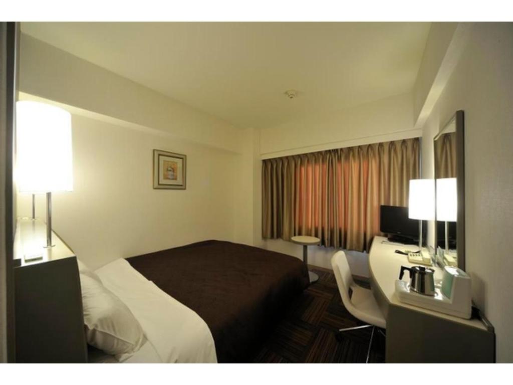 東京にあるGrand Central Hotel - Vacation STAY 19605vのベッドと机があるホテルの部屋