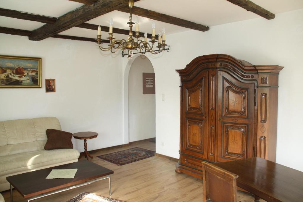 - un salon avec un canapé et une grande porte en bois dans l'établissement Ferienwohnung Domitian, à Millstatt