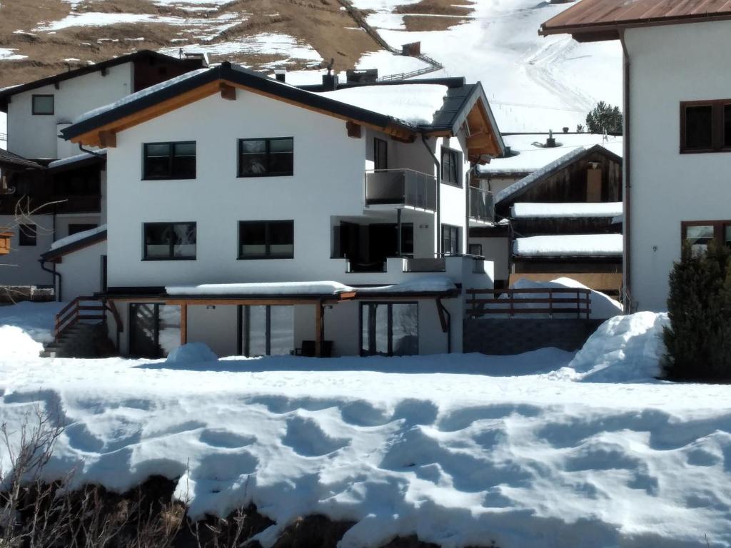 une maison dans la neige avec beaucoup de neige dans l'établissement Apart Alpenjuwel, à Sankt Leonhard im Pitztal