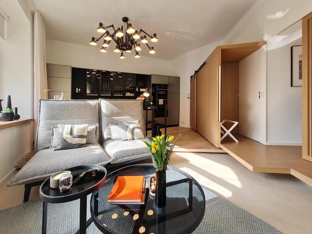 ein Wohnzimmer mit einem Sofa und einem Tisch in der Unterkunft Luxury Omuntu-Design-Apartment Deluxe in München