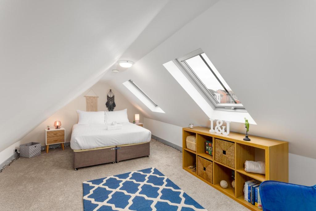 a attic bedroom with a bed and a window at Air Host and Stay - The Scouse House - Quirky 2 bedroom mews house mins from Sefton Park in Liverpool