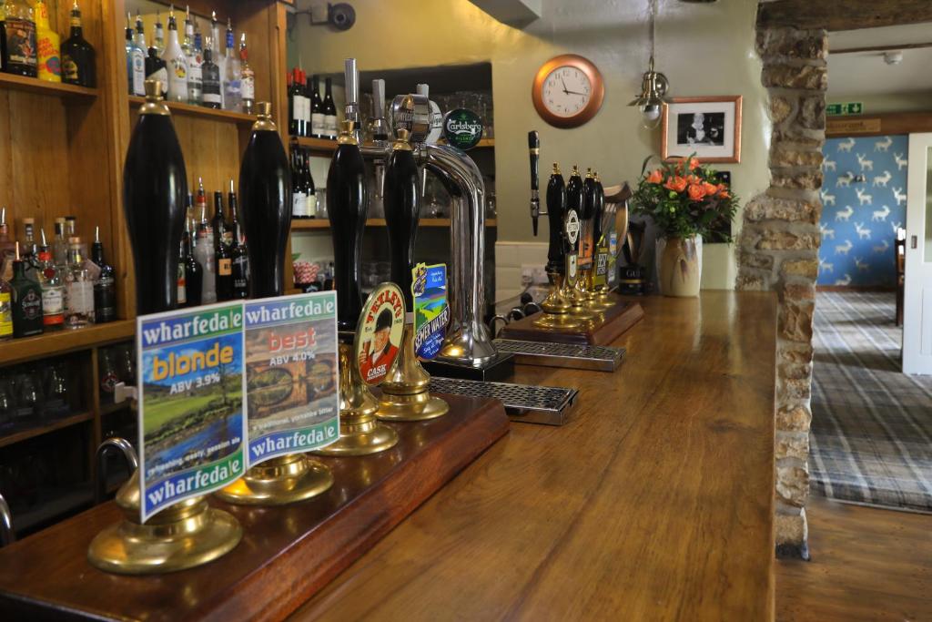 a bar with a counter with bottles of alcohol at The Blue Bell Inn in Kettlewell