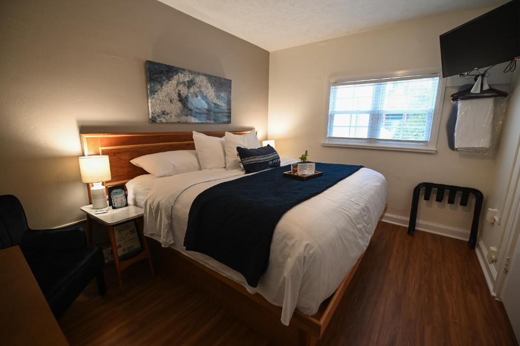 a bedroom with a large bed and a window at The Lakehouse Inn Geneva in Geneva-on-the-Lake