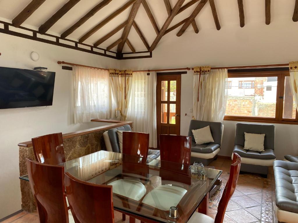 ein Wohnzimmer mit einem Glastisch und Stühlen in der Unterkunft BALCON DE CHIE in Villa de Leyva