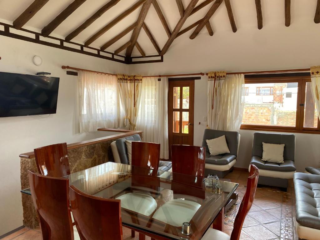 a living room with a glass table and chairs at BALCON DE CHIE in Villa de Leyva