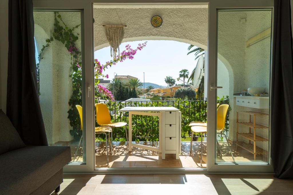 een open deur naar een terras met een tafel en stoelen bij Apartamento Retiro Sol in Denia