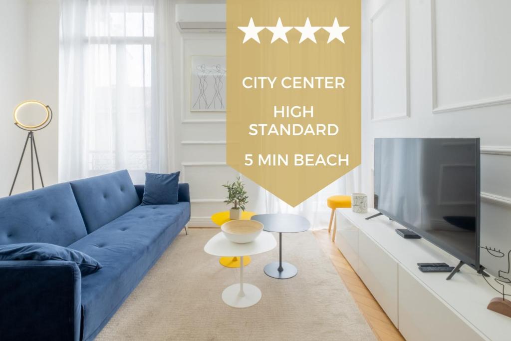 un salon avec un canapé bleu et une télévision dans l'établissement 3-Br Apartment in the heart of downtown, à Cannes