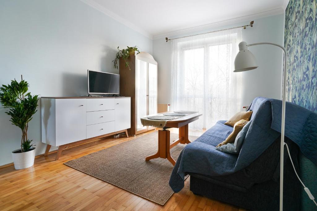 a living room with a blue couch and a table at Apartament Dana in Kołobrzeg